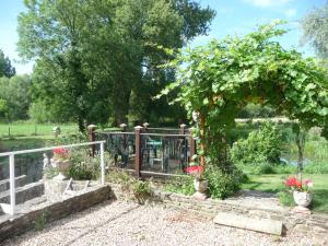 a garden with an arch and a fence with flowers at Salisbury Old Mill House in Salisbury +4 photos