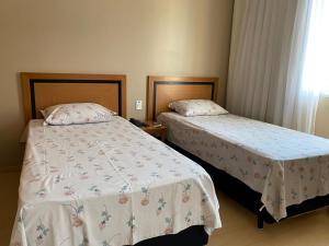 two beds in a hotel room withskirts at Flat, Savassi Condomínio Century in Belo Horizonte +11 photos