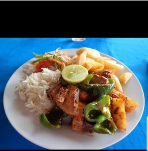 une plaque blanche de nourriture avec du riz et des légumes dans l'établissement Baraka Beach Bungalows, à Nungwi