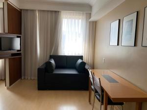 ein Wohnzimmer mit einem Sofa und einem Esstisch in der Unterkunft Flat, Savassi Condomínio Century in Belo Horizonte