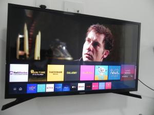 a flat screen tv with a man on it at Aconchego Serra Imperial-101 in Petrópolis