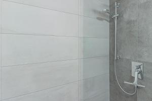 eine Dusche im Bad mit weißen Fliesen in der Unterkunft Residenz Brixental Top 7 in Brixen im Thale