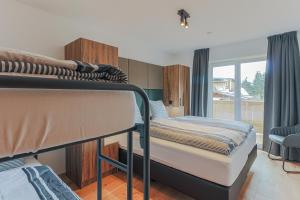 1 Schlafzimmer mit 2 Etagenbetten und einem Fenster in der Unterkunft Residenz Brixental Top 7 in Brixen im Thale