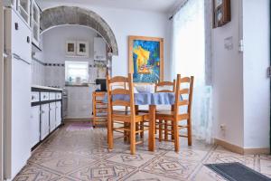 a kitchen with a table and chairs on a tiled floor at Casa D'Eira in Nordeste