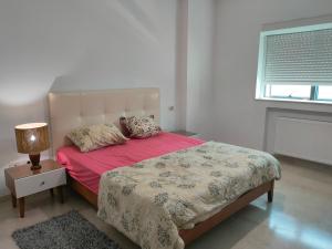 a bedroom with a bed with pink sheets and a lamp at FLAT JINEN DU LAC 2 in Tunis