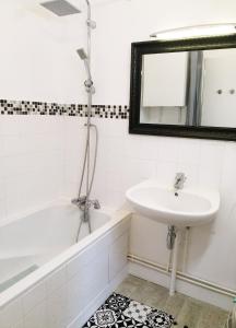 une salle de bain avec un lavabo, une baignoire et un miroir dans l'établissement Jolie maison avec jardin clos - Fontainebleau Héricy, 35 min Paris, à Héricy 39 autres photos