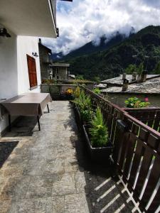 einen Balkon mit einem Tisch und Pflanzen auf einem Gebäude in der Unterkunft Casa Lana in Chiesa in Valmalenco