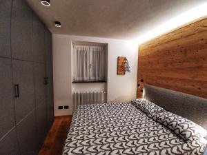 a bedroom with a large bed with a wooden headboard at Casa Lana in Chiesa in Valmalenco