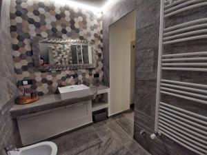ein Bad mit einem Waschbecken und einem Spiegel in der Unterkunft Casa Lana in Chiesa in Valmalenco