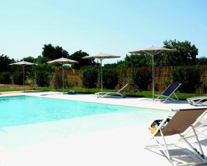 ガラティーナにあるVilla Galluccio with swimming poolのスイミングプール(椅子2脚、パラソル付)