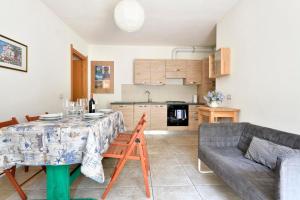a kitchen and living room with a table and a couch at Appartamento Pini in Cala Gonone