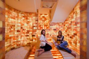 two women sitting on a wall in a hotel room at Szőnyi Garden Hotel Pest in Budapest