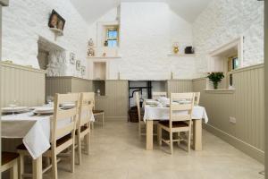 uma sala de jantar com mesas e cadeiras num edifício em Abhainn Ri Farmhouse em Blessington