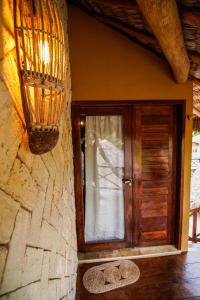 Habitación con puerta de madera y ventana en Pousada Rota dos Ventos en Barra Grande