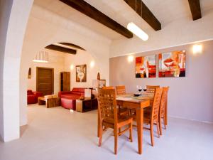a dining room and living room with a table and chairs at Girgentina in Xagħra