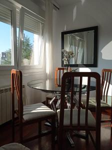 a dining room with a table and chairs and a mirror at Apartamento Santa Marta in Santiago de Compostela