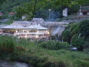a building with lights in front of a waterfall at Apartman Mira&Ahmet in Stolac