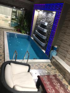 a swimming pool with a chair and a tub at Apartment Nazaha for families only in Tangier