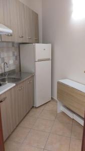 una cucina con frigorifero bianco e lavandino di Dabliu House a Torrenova