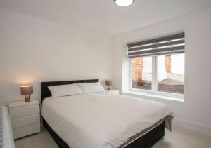a white bedroom with a large bed and a window at Luxurious oasis relax 32c pool, jacuzzi games bar in Deal +24 photos