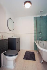 a bathroom with a toilet and a tub and a sink at Luxurious oasis relax 32c pool, jacuzzi games bar in Deal