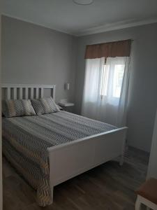 アルヌエロにあるApartamentos San Juanの大きなベッドと窓のある寝室