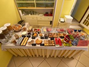 une table contenant de nombreux types de denrées alimentaires différents dans l'établissement Hotel Il Parco Sirolo, à Sirolo