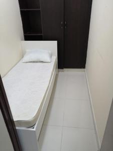 ein weißes Bett in einem Zimmer mit weißem Boden in der Unterkunft Low-Priced Budget Rooms for rent near Dubai DAFZA in Dubai