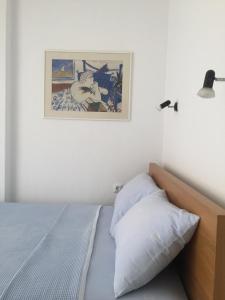 a bedroom with a bed and a picture on the wall at Luminous house 100m from the sea in Nea Roda