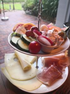 um prato de alimentos em três níveis sobre uma mesa em Hotel garni Haus am Meer em Neuharlingersiel