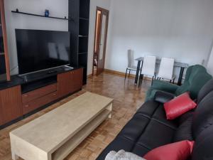 sala de estar con sofá y TV de pantalla plana en Lizarra 49, en Estella