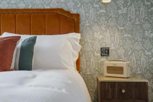 a bedroom with a bed and a small tv on a night stand at Bel And The Dragon-Churt in Farnham