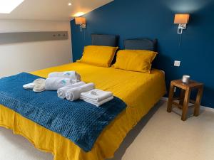 a bedroom with a yellow bed with towels on it at Le Dôme et son jacuzzi in Grazac