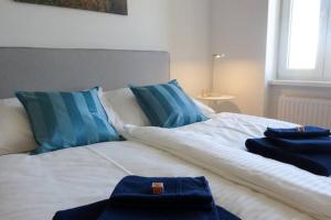 ein Bett mit blauen Kissen und blauen Handtüchern darauf in der Unterkunft Studio-Apartment between Schoenbrunn & the City Center (28) in Wien