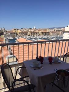 a table on a balcony with a view of a city at Suite privée du balcon du vieux port Marseille in Marseille