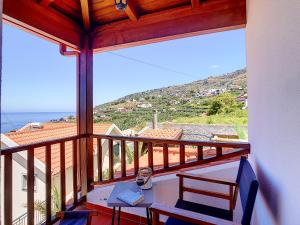 a balcony with a table and chairs and the ocean at Pôr do Sol by LovelyStay in Calheta