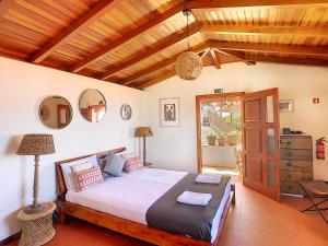 a bedroom with a bed and a wooden ceiling at Pôr do Sol by LovelyStay in Calheta