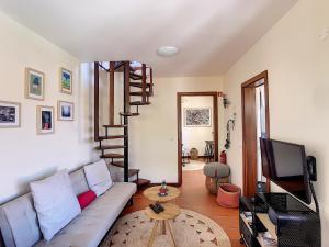 a living room with a couch and a television at Pôr do Sol by LovelyStay in Calheta