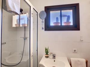 a bathroom with a shower and a sink and a window at Pôr do Sol by LovelyStay in Calheta +15 photos