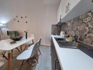 a kitchen with a sink and a table with chairs at Cosy and modern appartment in Olympiada in Olympiada
