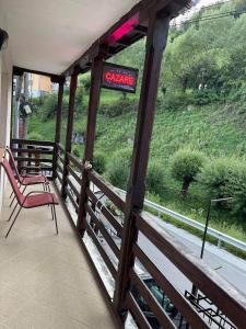 a porch with a chair and a sign on a hill at Vila Maria Dambovicioara in Dîmbovicioara +59 photos