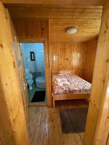 a small room with a bed in a wooden cabin at Vila Maria Dambovicioara in Dîmbovicioara