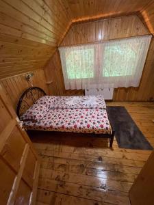 ein Bett in einem Holzzimmer mit Fenster in der Unterkunft Vila Maria Dambovicioara in Dâmbovicioara + 62 Fotos