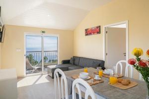 a living room with a table and a couch at OurMadeira - SeaView Apartment, countryside in Calheta