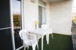 a white table and two chairs on a balcony at Гостевой дом SUN TAG in Chornomors'ke