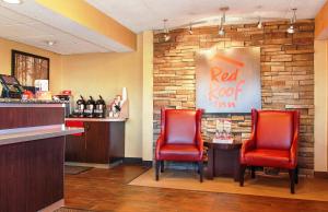 カントンにあるRed Roof Inn Cantonの赤い椅子2脚とバー付きのレストラン