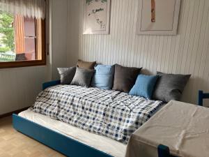 een blauwe bank met een deken erop in een kamer bij Le Gildien in Bardonecchia +24 foto's