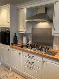 a kitchen with white cabinets and a stove top oven at Parkside Mews in Frizington
