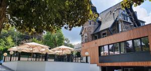 un ristorante con ombrelloni di fronte a un edificio di Villa les érables Restaurant Linea a Spa