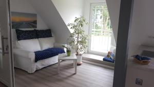 ein Wohnzimmer mit einem weißen Sofa und einem Tisch in der Unterkunft Villa Wiese in Katzow